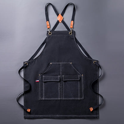 WorkEase black canvas apron laid flat, showing the crossback straps and four front pockets