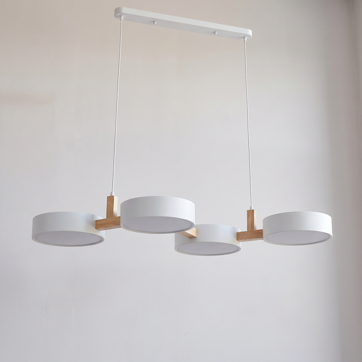 Tavola pendant seen from above, the four discs weaving in and out of line on short wood links