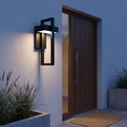 Framed outdoor wall lamp beside a front door at dusk
