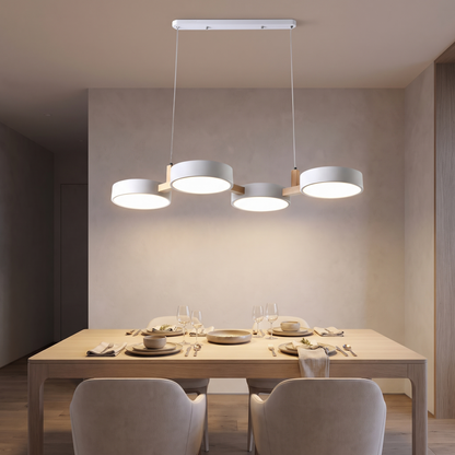 Tavola four-head pendant over a set dining table, discs weaving in and out of line